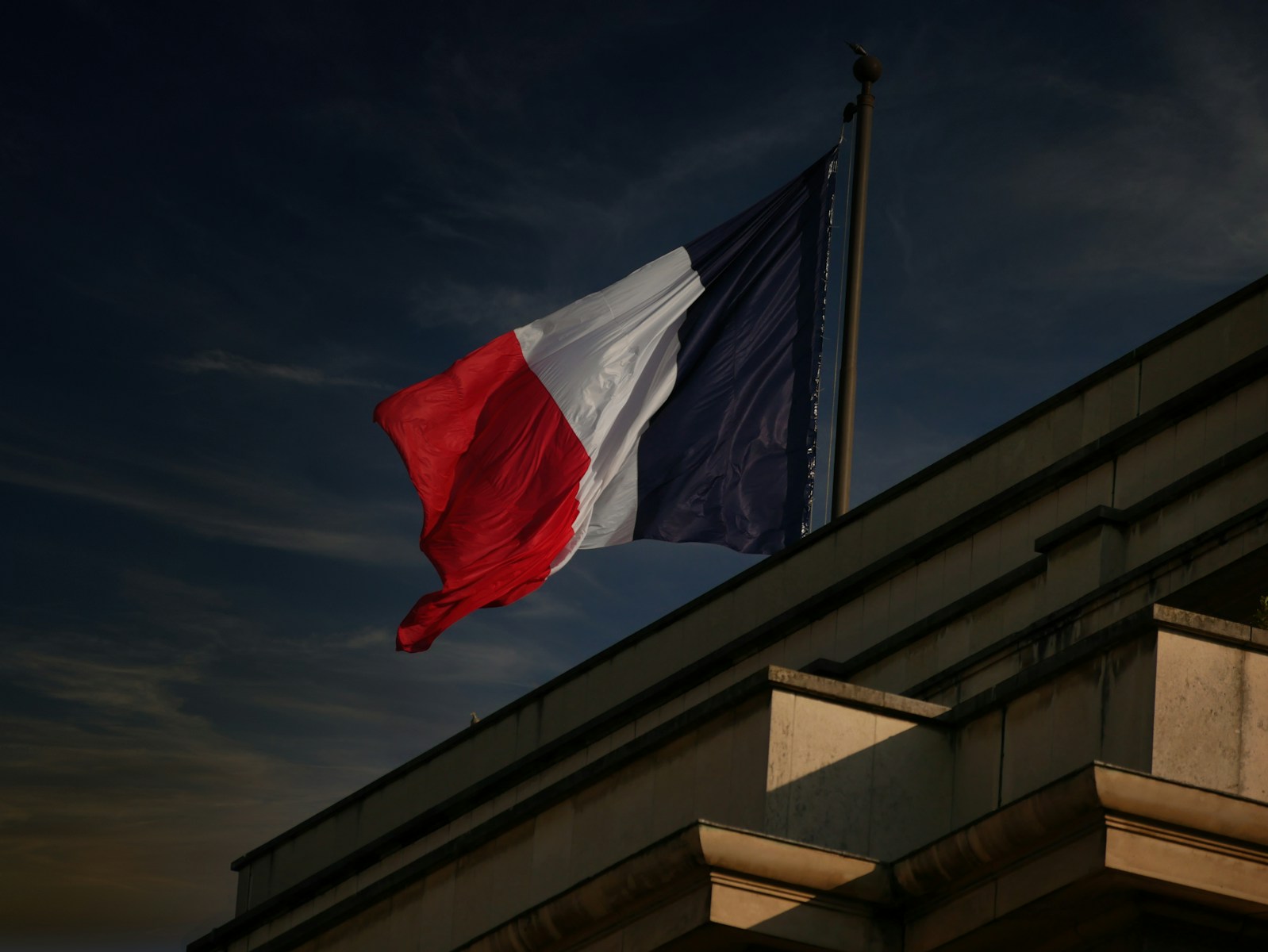 A french flag flies in the sky.